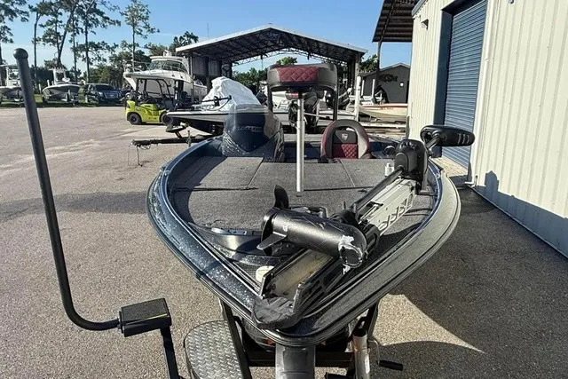 Slide: The Image of A 2019 Triton 20 TrX Patriot boat is on a trailer in a storage area. - 8