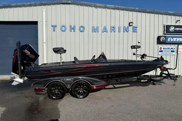 The Image of A black 2019 Triton 20 TrX Patriot boat on a trailer in front of a building. - 1
