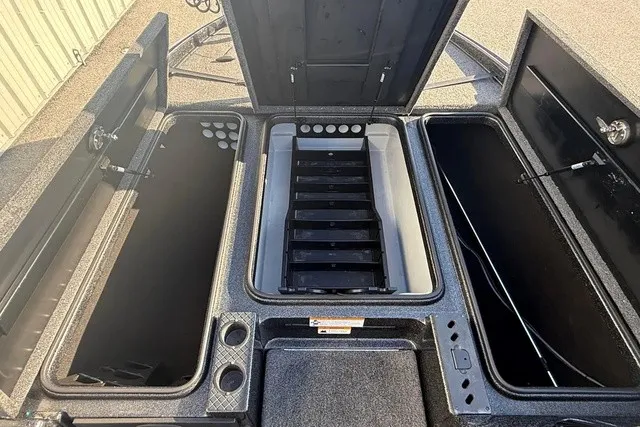 Slide: The Image of The image shows the storage compartments of a 2019 Triton 20 TrX Patriot boat with open hatches. - 14