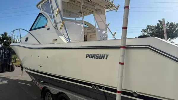 Slide: The Image of 2007 Pursuit OS 335 Offshore with a white hull and cabin, on a trailer. - 5