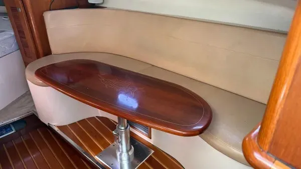 Slide: The Image of Interior of a 2007 Pursuit OS 335 Offshore with a sleek wooden table and beige sofa. - 14