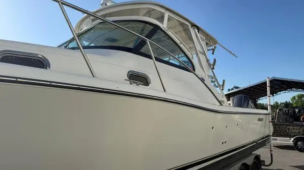 Slide: The Image of A white 2007 Pursuit OS 335 Offshore boat is on land under a blue sky. - 6