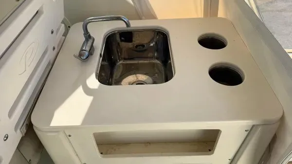Slide: The Image of The image shows a small sink with a faucet and two round storage areas on a boat. - 22