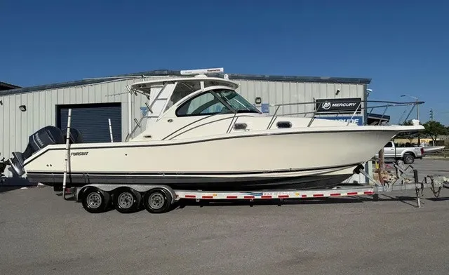 The Image of A 2007 Pursuit OS 335 Offshore boat on a trailer in front of a building. - 1
