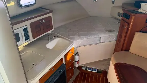 Slide: The Image of The cabin of the 2007 Pursuit OS 335 Offshore features a kitchenette, sink, and sleeping area. - 15