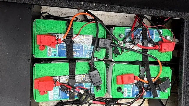 Slide: The Image of Four green boat batteries are neatly connected with cables and stored in a compartment. - 15