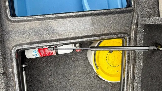 Slide: The Image of An open storage compartment in a boat with a fire extinguisher and a yellow bucket. - 14