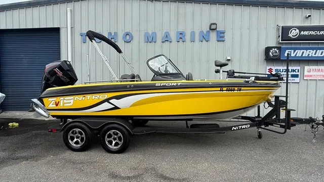 The Image of A yellow 2022 Nitro ZV19 sport boat on a trailer in front of a building. - 1