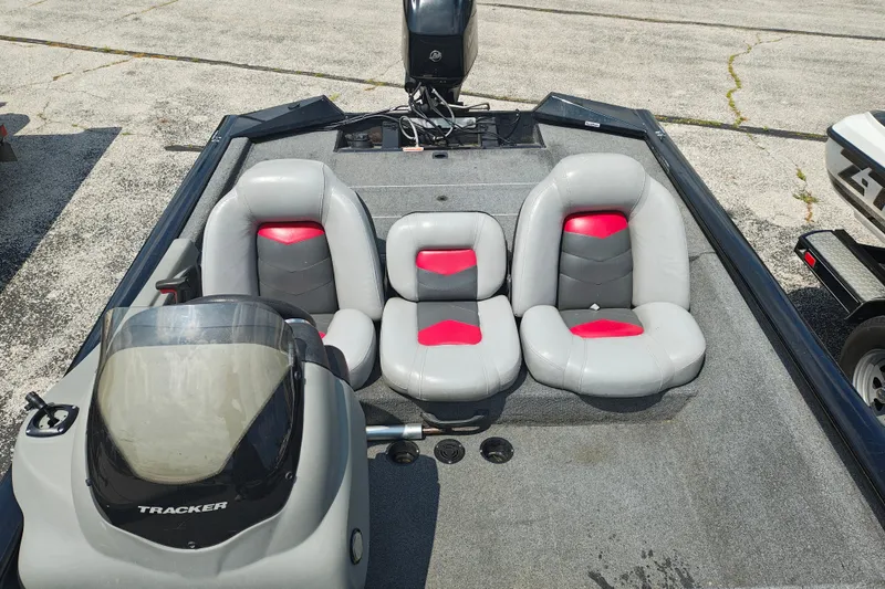 Slide: The Image of 2016 Tracker Pro Team 175 TXW boat interior with gray and red seating. - 14