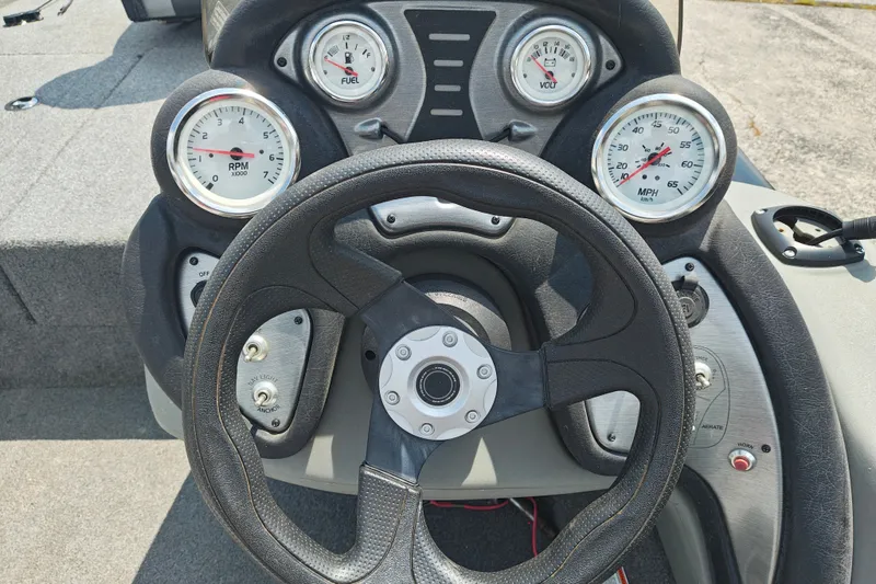 Slide: The Image of Steering wheel and dashboard of 2016 Tracker Pro Team 175 TXW boat, featuring gauges and controls. - 16