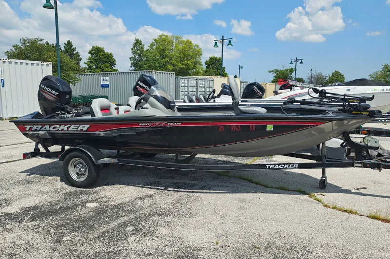The Image of 2016 Tracker Pro Team 175 TXW boat on trailer, parked outdoors under a clear sky. - 1