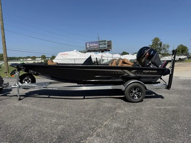 The Image of A black Xpress Hyper-Lift Bass H18 boat from 2026 on a trailer, parked in a lot. - 1