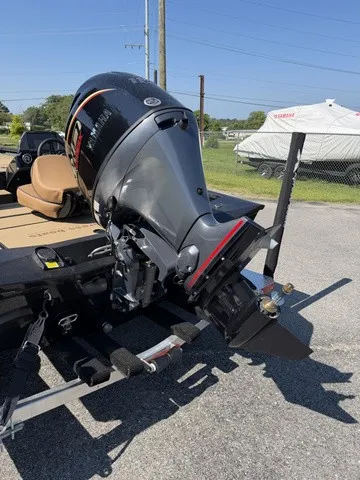 Slide: The Image of A powerful outboard motor on an Xpress Hyper-Lift Bass H18 boat, parked on a trailer. - 4