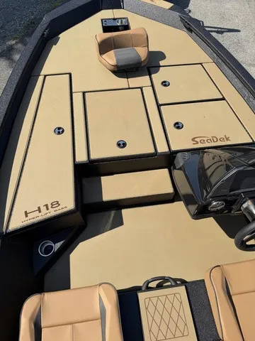 Slide: The Image of The image shows the deck of an Xpress Hyper-Lift Bass H18 boat with beige upholstery. - 7