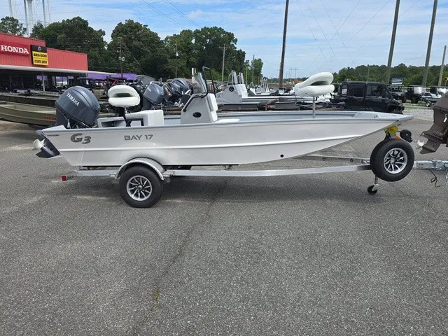 Slide: The Image of A white G3 Bay 17 boat on a trailer, parked in a lot. - 6