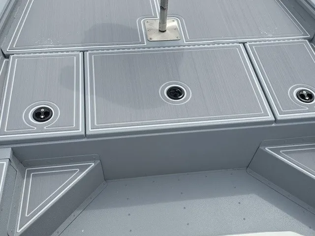Slide: The Image of The image shows the gray deck of a G3 Bay 17 boat with round drainage openings. - 19