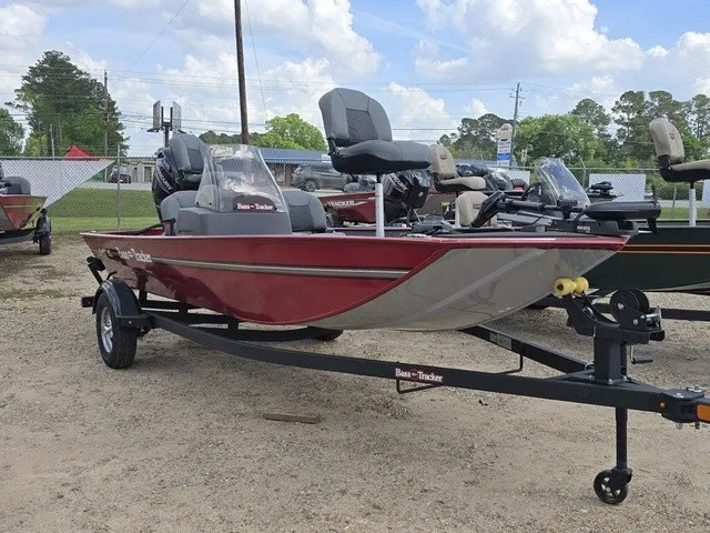 Slide: The Image of A red 2025 Bass Tracker Classic XL boat sits on a trailer in a gravel lot. - 3