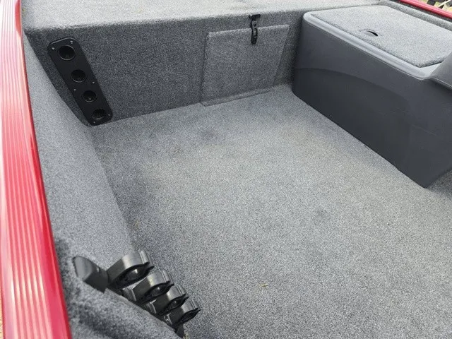 Slide: The Image of The interior of a 2025 Tracker Bass Tracker Classic XL with gray carpeting and storage compartments. - 19