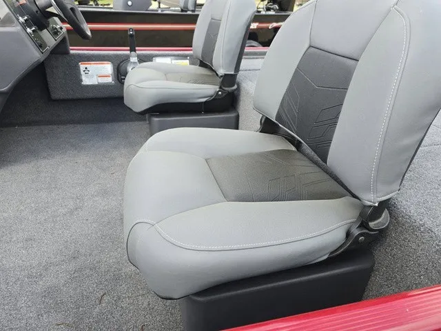 Slide: The Image of Two gray seats in a boat with red trim and gray carpeted flooring. - 17