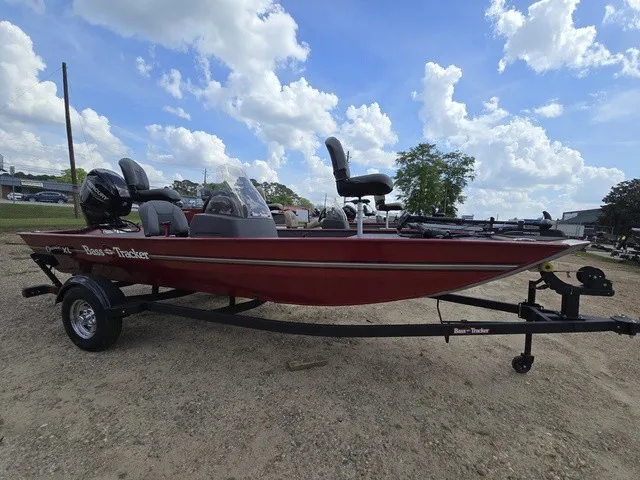 Slide: The Image of A red Bass Tracker Classic XL boat from 2025 sits on a trailer under a cloudy sky. - 4