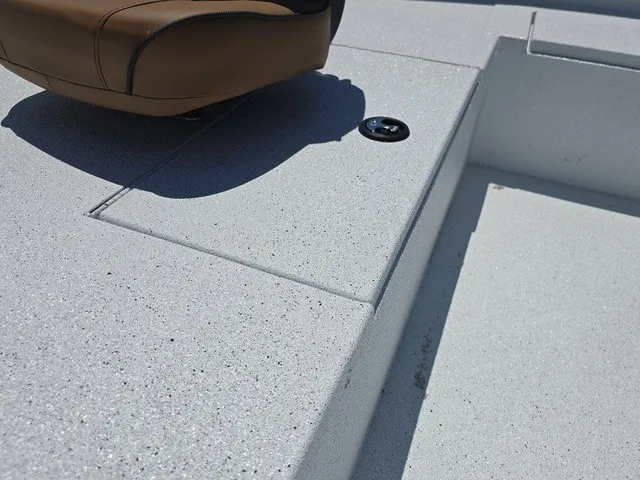 Slide: The Image of Close-up of a boat deck with a brown seat and a black button. - 14
