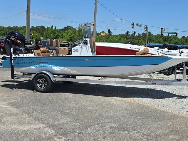 Slide: The Image of A 2026 Xpress SW20B boat on a trailer, featuring a blue hull and outboard motor. - 6