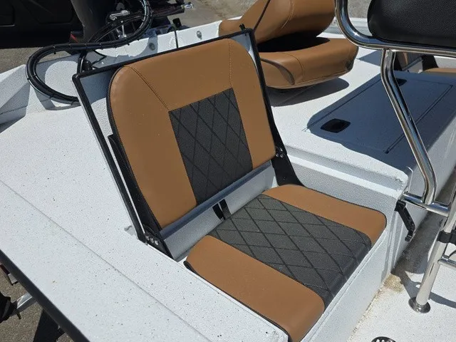 Slide: The Image of A seat with brown and black upholstery on a boat, surrounded by white decking. - 20