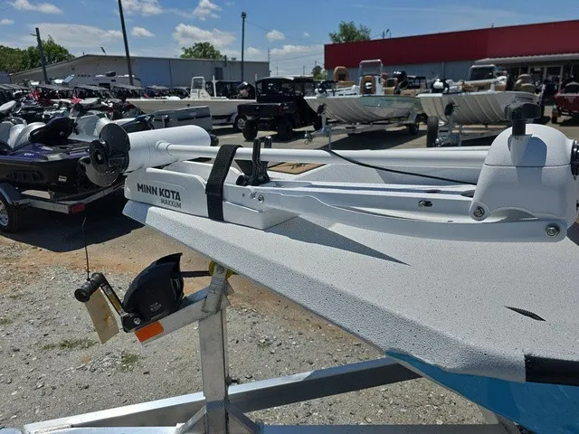 Slide: The Image of An Xpress SW20B boat with a Minn Kota trolling motor, parked on a trailer outdoors. - 12