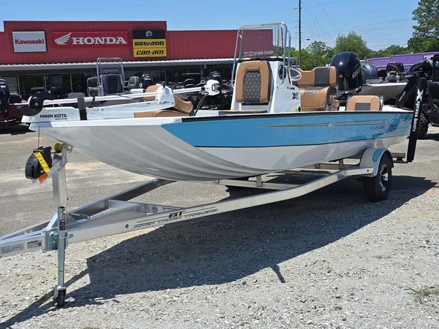 Slide: The Image of A 2026 Xpress SW20B boat on a trailer, featuring a blue and white design and outboard motor. - 2