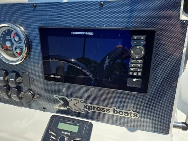 Slide: The Image of Close-up of a boat dashboard featuring a Humminbird screen and Xpress logo. - 25