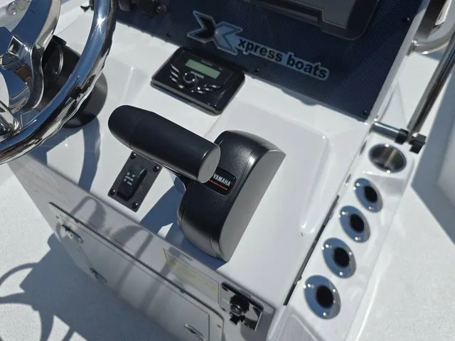 Slide: The Image of Close-up of the helm of an Xpress SW20B boat with Yamaha throttle and cup holders. - 27