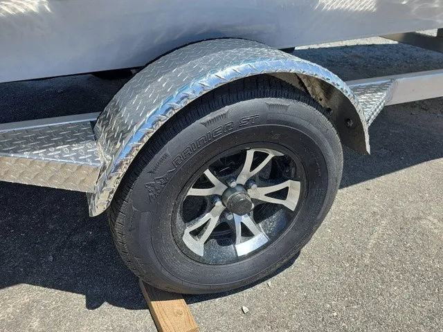 Slide: The Image of Close-up of a boat trailer with a sturdy tire and diamond-patterned fender. - 32