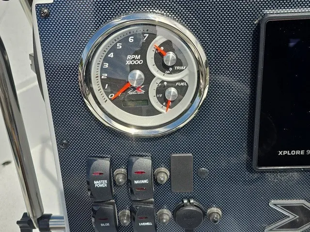 Slide: The Image of Close-up of a boat instrument panel with a tachometer and various switches. - 28
