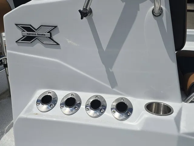 Slide: The Image of Close-up of a white boat console area with four cup holders and an Xpress logo. - 21