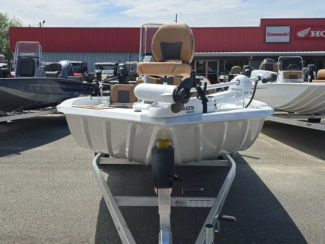 Slide: The Image of A 2026 Xpress SW20B boat on a trailer, parked in front of a store. - 16