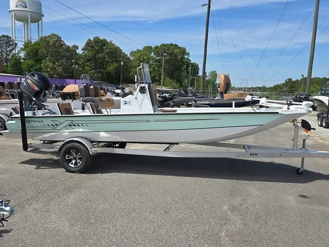 Slide: The Image of A 2026 Xpress SW20B boat on a trailer, surrounded by other boats outdoors. - 13