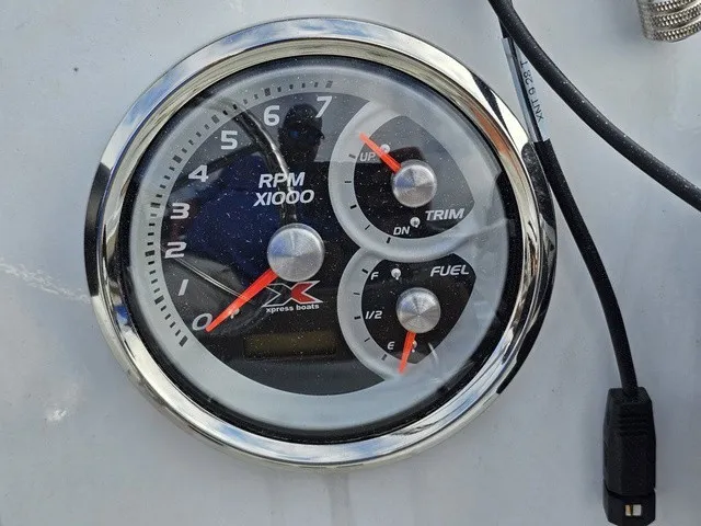 Slide: The Image of A round gauge with tachometer, trim, and fuel indicators, mounted on a boat. - 26