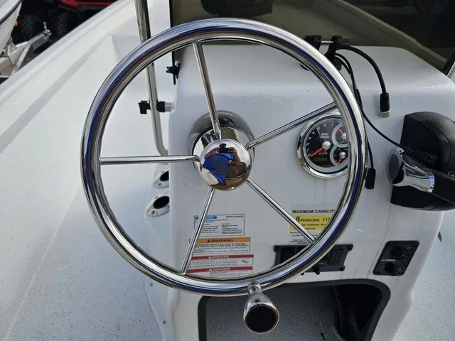 Slide: The Image of The image shows the helm of an Xpress XP20CC boat with a shiny metal steering wheel and gauges. - 24