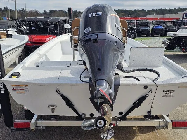 Slide: The Image of A 2026 Xpress XP20CC boat with a 115 HP outboard motor, parked on a trailer. - 32