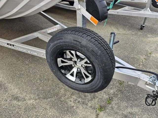 Slide: The Image of A boat trailer with a black wheel and silver rims on a concrete surface. - 11
