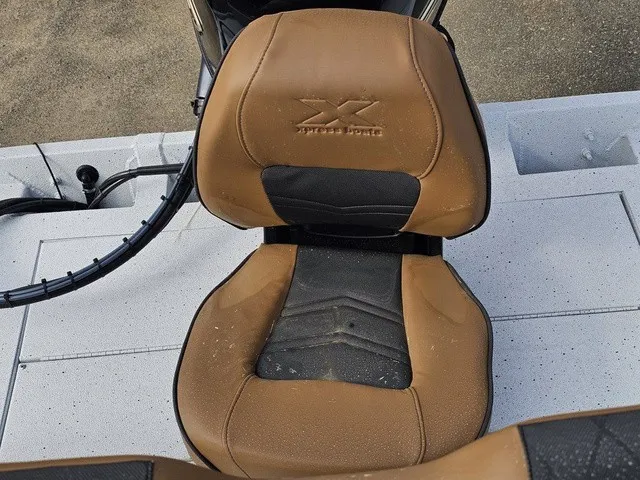 Slide: The Image of A brown boat seat with black insert and Xpress Boats logo on a gray deck. - 22