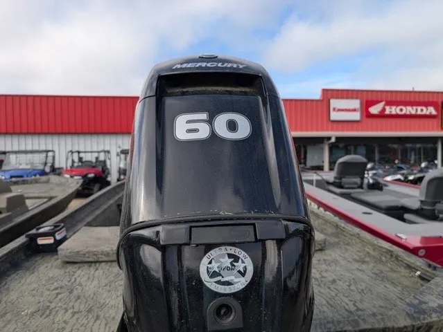 Slide: The Image of A Mercury 60 horsepower outboard motor is mounted on a boat. A red building and other boats are visible in the background. - 16