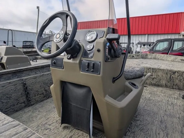 Slide: The Image of The image shows the helm of a Tracker Grizzly 1860 CC boat with a rugged design. - 11