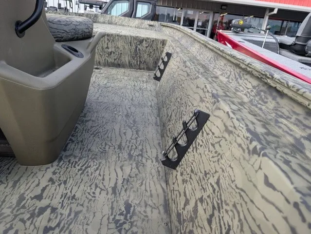 Slide: The Image of The image shows the interior of a Tracker Grizzly 1860 CC boat with a textured surface and rod holders. - 12