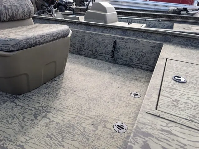 Slide: The Image of The image shows the interior of a Tracker Grizzly 1860 CC boat with a camo design. - 7