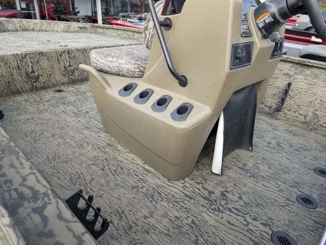 Slide: The Image of The image shows the cockpit of a Tracker Grizzly 1860 CC boat with a rugged, textured floor. - 24