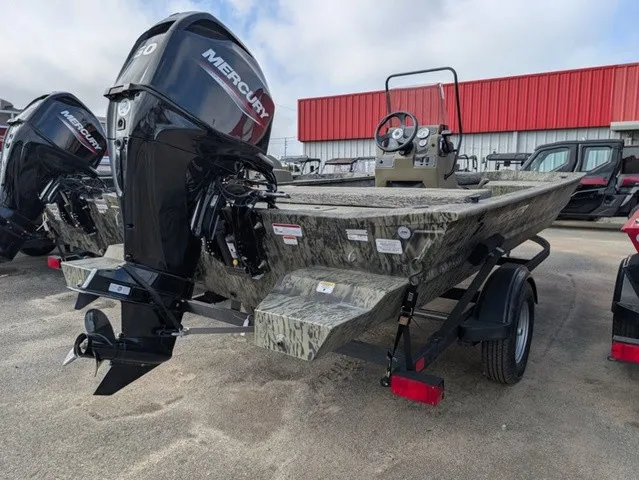 Slide: The Image of A Tracker Grizzly 1860 CC boat with a Mercury outboard motor, parked on a trailer. - 14