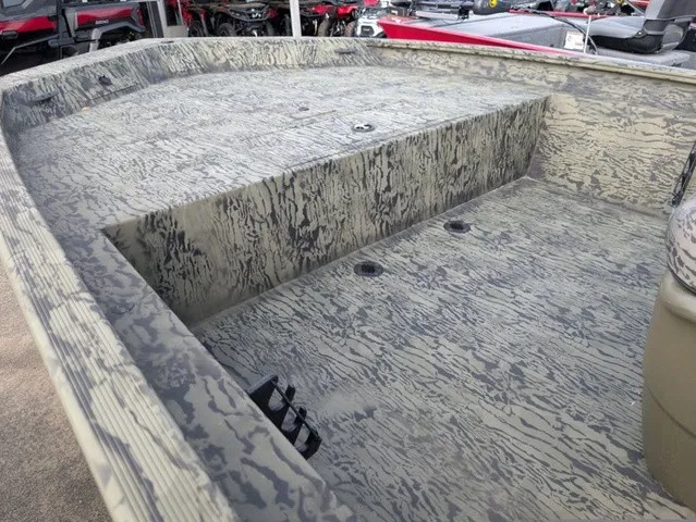 Slide: The Image of The image shows the deck of a Tracker Grizzly 1860 CC boat with a camouflage pattern. - 27