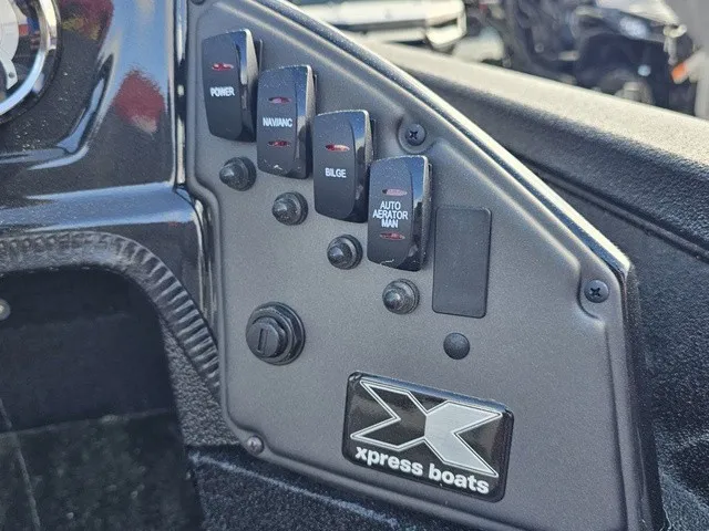 Slide: The Image of Close-up of the dashboard on an Xpress H18C Crappie boat featuring various switches. - 25