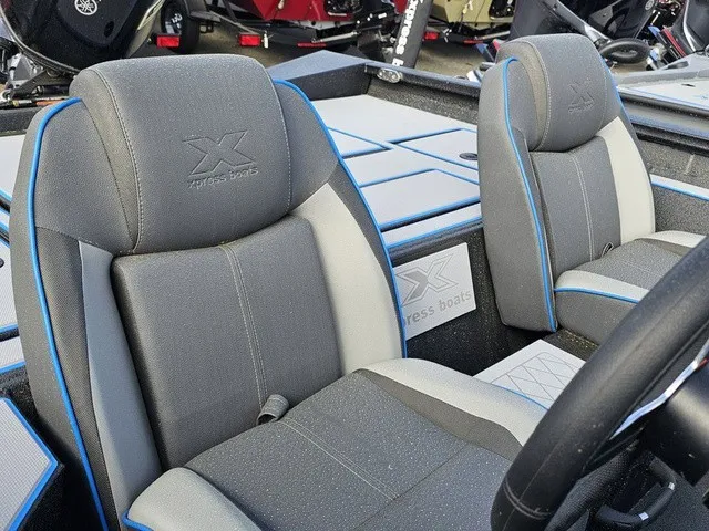 Slide: The Image of Interior of the 2026 Xpress H18C Crappie with gray seats and blue accents. - 22